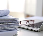 Stack of legal papers next to laptop